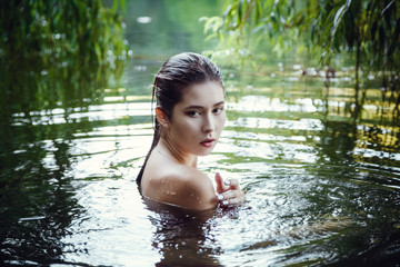 Fototapeta premium Beautiful young girl resting in water