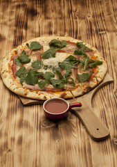 Pizza Parmigiana on wooden board served with ketchup