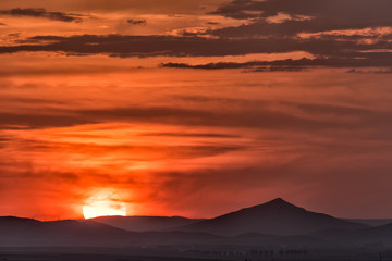 Beautiful landscape with a big setting sun over the hills, Dobrogea , Romania