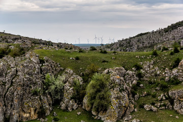 Beautiful landscape with green vegetation, rocks and wind turbines, Cheile Dobrogei, Romania