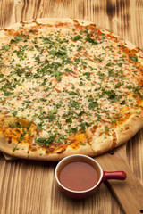Pizza Apolonia on wooden board served with ketchup