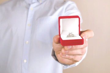 Engagement / marriage / wedding proposal scene. Close up of man handing the expensive gold platinum diamond ring to his bride.