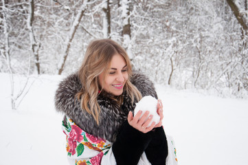 A happy woman walks through the winter forest, plays with snowballs, laughs and enjoys life.