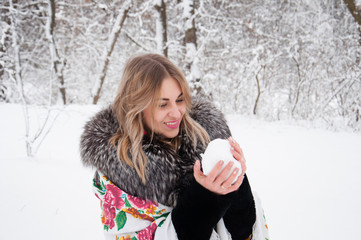 A happy woman walks through the winter forest, plays with snowballs, laughs and enjoys life.