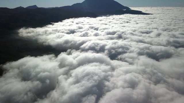 The sea of clouds up above the sky and the view of the tip of a mountain