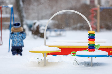 Ребёнок на детской площадке зимой
