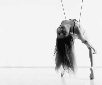 Perfect slim girl with a rope posing on a light background. Sexy athletic body. black and white