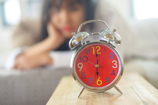 A young woman putting her alarm clock off in the morning
