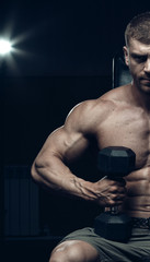 Fototapeta na wymiar Male bodybuilder, fitness model trains in the gym