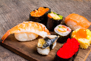 Sushi Set sashimi and sushi rolls served on wood slate