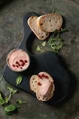 Chicken homemade liver paste or pate with sliced whole grain bread, wood knife, cranberries, green...