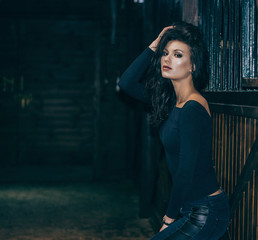 Portrait of an attractive brunette in a stable. Lifestyle Photo. Fashion photo.