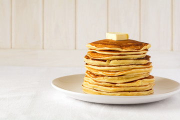 Stack of pancakes with butter and honey on white background © thayra83