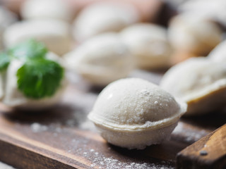 Frozen raw dumplings on the wooden desk on black background