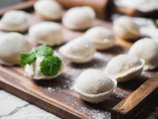 Fototapeta na wymiar Frozen raw dumplings on the wooden desk on black background