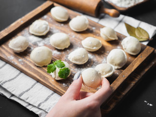 Frozen raw dumplings on the wooden desk on black background