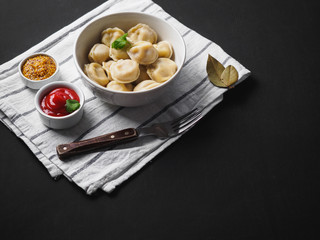 Dumplings on plate at wooden desk on black background