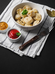 Dumplings on plate at wooden desk on black background