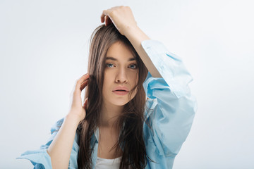 Naklejka premium Exhausted life. Reflective beautiful good looking woman staring straight and touching hair while lost in dreams 