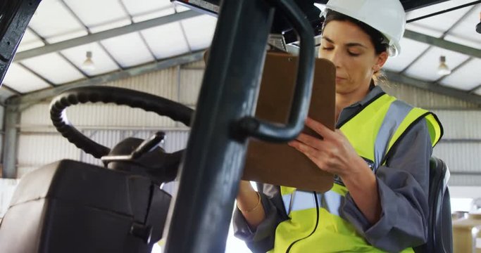 Female technician writing in clipboard 