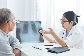Young female doctor examining x-ray film.