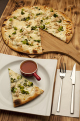 Pizza with chicken and broccoli on wooden board served with ketchup
