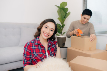 Portrait of happy woman during moving home  carrying carton boxes