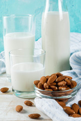 Vegan alternative food, almond non-dairy milk on light blue background, copy space