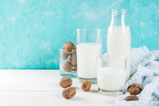 Vegan alternative food, walnut non-dairy milk on light blue background, copy space