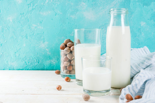 Vegan alternative food, hazelnut non-dairy milk on light blue background, copy space