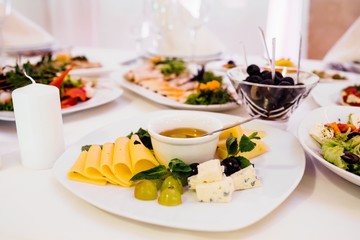 Photo of cheese platter and salad on the table