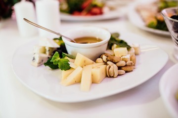 Photo of cheese platter and salad on the table