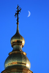 Crescent moon near the cross on top of St. Michael's Golden-Domed Monastery in Kyiv, Ukraine © aquatarkus