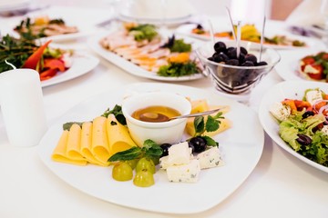 Photo of cheese platter and salad on the table