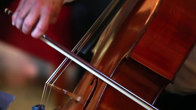 Man Hand Playing Violoncello With Cello Bow. Close up of Male Hand Playing Cello With Cello Bow. Classical Orchestra Musician