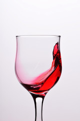Glasses with waves plash of red wine on a white background