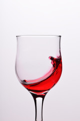 Glasses with waves plash of red wine on a white background