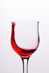 Glasses with waves plash of red wine on a white background