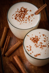 Eggnog houmemade with cinnamon and kakao for Christmas and winter holidays or wooden broun backgrounds