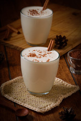 Eggnog houmemade with cinnamon and kakao for Christmas and winter holidays or wooden broun backgrounds