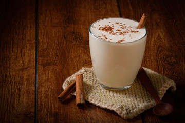 Eggnog houmemade with cinnamon and kakao for Christmas and winter holidays or wooden broun backgrounds