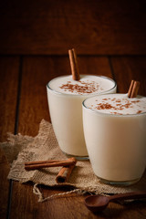 Eggnog houmemade with cinnamon and kakao for Christmas and winter holidays or wooden broun backgrounds