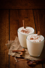 Eggnog houmemade with cinnamon and kakao for Christmas and winter holidays or wooden broun backgrounds