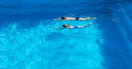 Young father and child swimming in the swimming pool. View from above