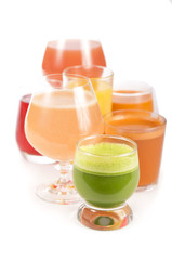 Glasses with fresh organic vegetable and fruit juices isolated on white.