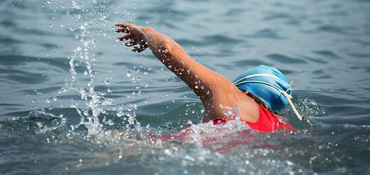 Woman swimmer swimming crawl in blue sea,training for triathlon
