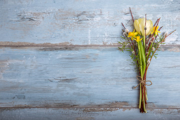 Background with light yellow tulips on blue wooden desk. Easter, Mother's, Valentines, Women's Day.Top view with copy space. Place for text.