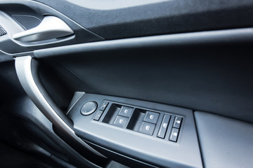 Car interior details of door handle with windows controls