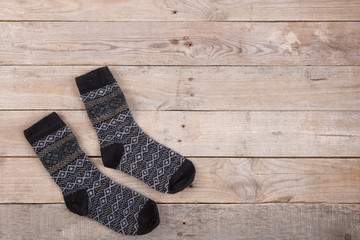 Knitted warm socks on the wooden background