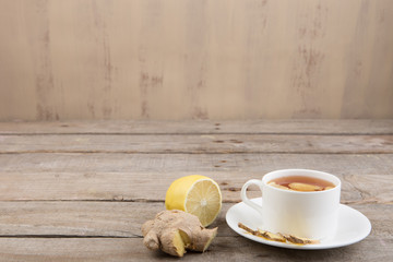 Ginger tea in a cup on wooden background